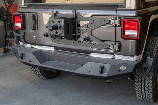 DV8 Offroad Jeep Wrangler JL chase rack with tailgate-mounted tire carrier, rugged offroad vehicle accessory on a black Jeep.