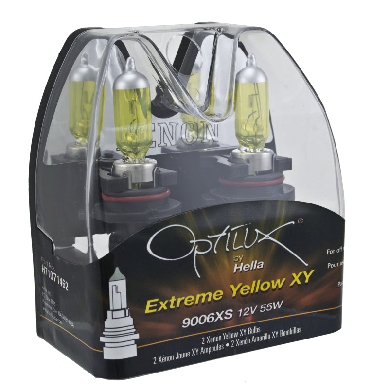 Hella 9006XS 12V 55W Xen Pure yellow car headlight bulbs, pair, shown installed in a vehicle headlight assembly.