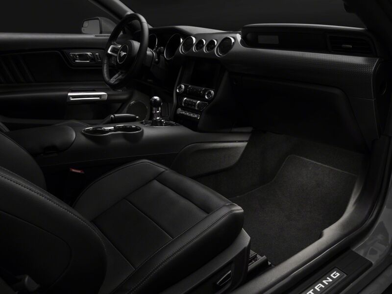 Raxiom Ford Mustang LED footwell lighting kit in white installed inside the vehicle, illuminating the interior footwell area.