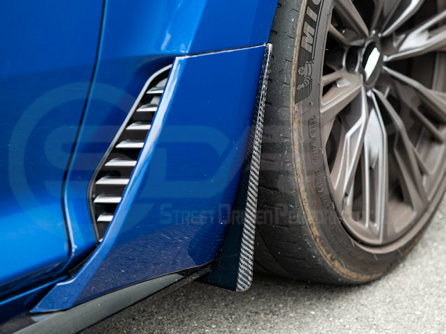 Pair of black carbon fiber mud flaps for 2022-up Cadillac CT5-V Blackwing, designed to protect the vehicle's front and rear splash areas.