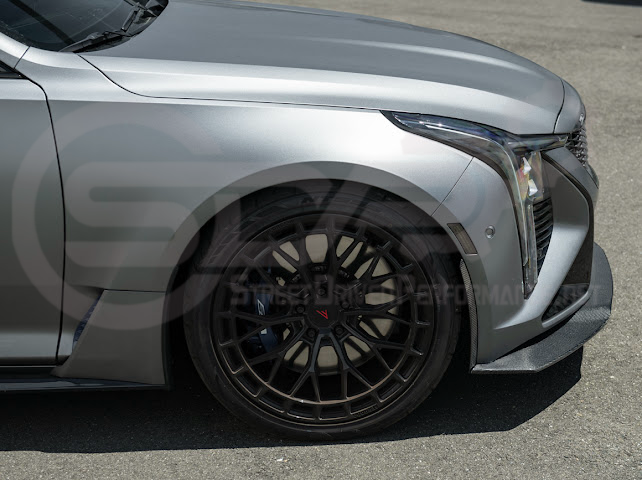 Cadillac CT5-V Blackwing factory OEM style carbon fiber front lip splitter and wheel arches on the car's ground effects.