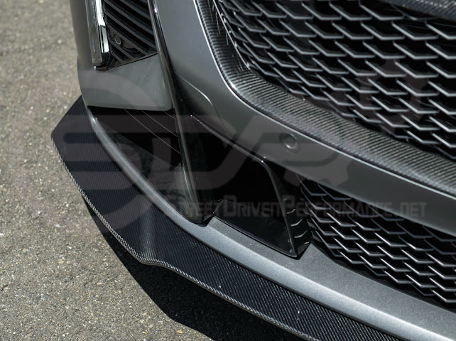 Black Cadillac CT5-V Blackwing factory OEM style carbon fiber front lip splitter and wheel arches, ground effects enhancement.