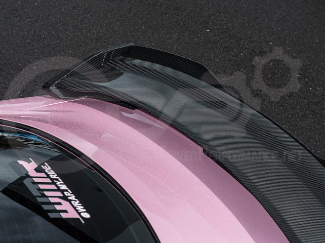 Dark Horse style carbon fiber rear wickerbill spoiler wing for 2015-2023 Ford Mustang, shown on a sleek sports car.