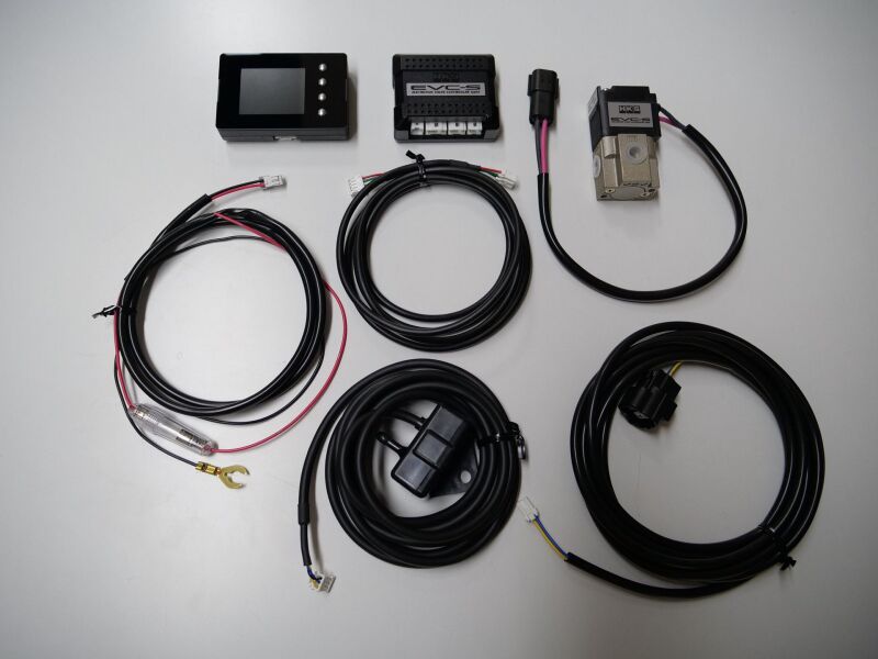 HKS EVC S2 boost controller with black and silver design, mounted on a vehicle's dashboard for tuning and performance adjustment.