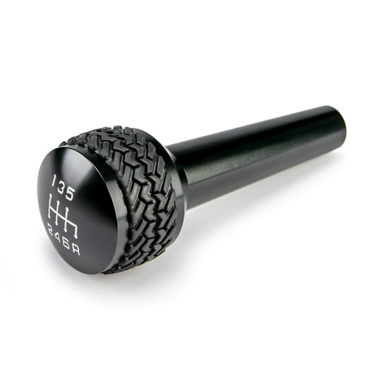 Black finish DV8 Offroad 2005-2010 Jeep TJ/JK 6-speed shift knob, close-up showing textured surface and ergonomic design.