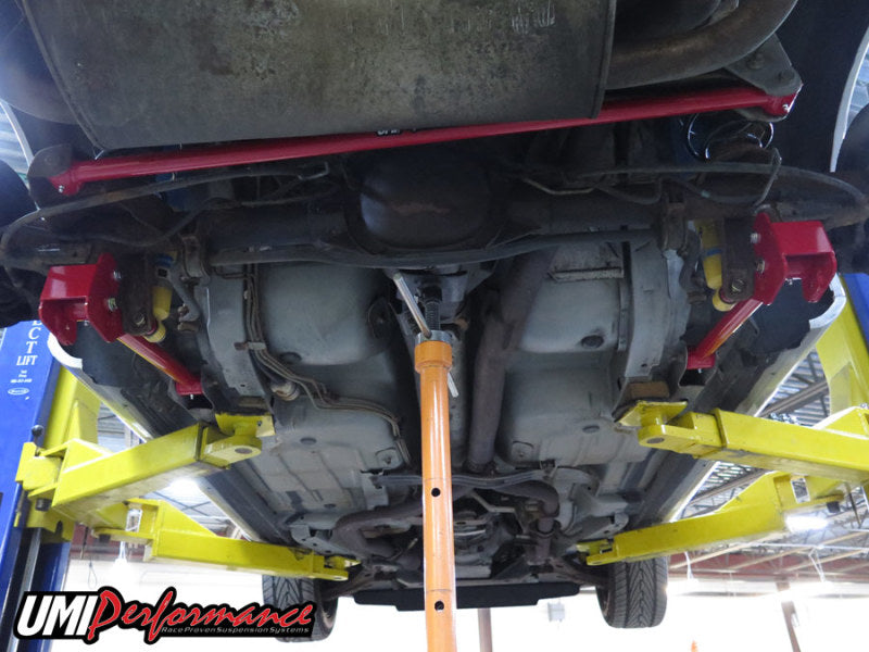 UMI Performance GM F-Body tubular non-adjustable panhard bar, black metal with mounting brackets, for vehicle suspension stability.