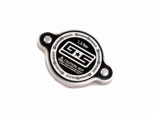 Black GrimmSpeed Subaru 1.3 Bar Radiator Cap installed on engine reservoir, showcasing durable metal construction and secure fitting.