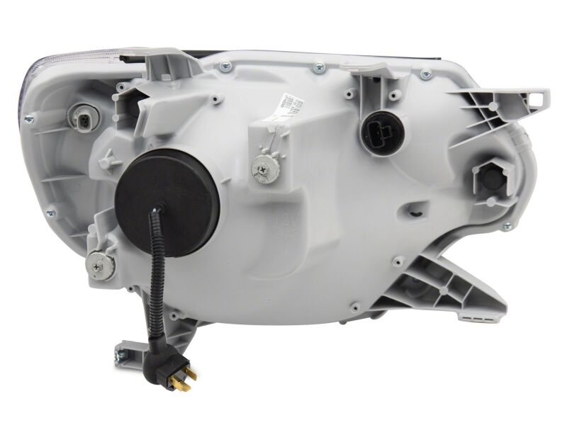 Raxiom 12-15 Toyota Tacoma Axial Series switchback projector headlights with chrome finish and clear lenses, mounted on a vehicle.