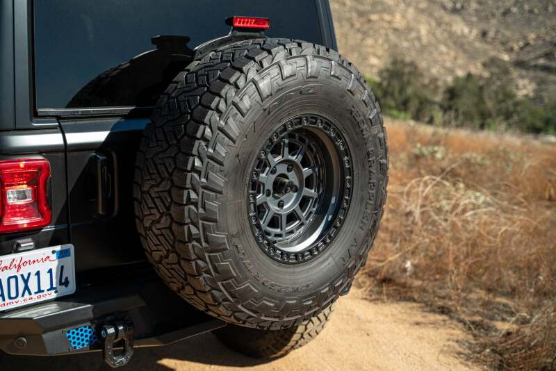 DV8 Offroad Jeep Wrangler JL MTO Series bumper spare tire swing gate tailgate accessory showing mounted spare tire and bumper details.