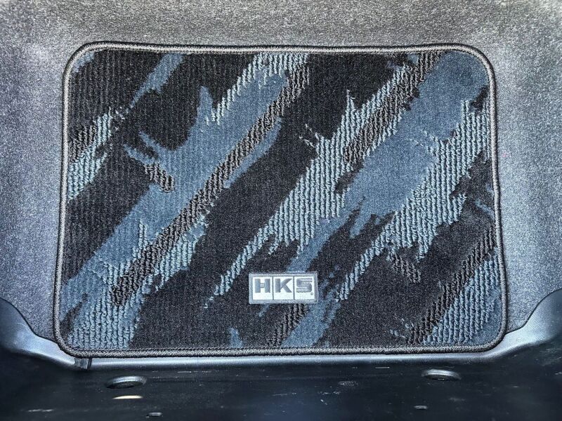 HKS carpeted floor mats full set for ND Mazda, driver and passenger side, with detailed textured surface and branding.