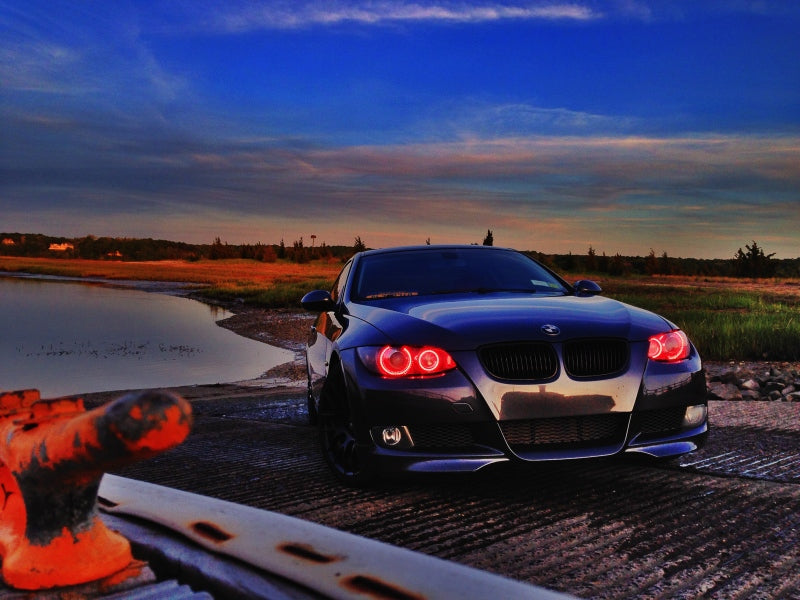 Blue Oracle LED projector headlight halo kit installed in a BMW 3 Series 2006-2011, showcasing bright blue halo rings and headlight detail.