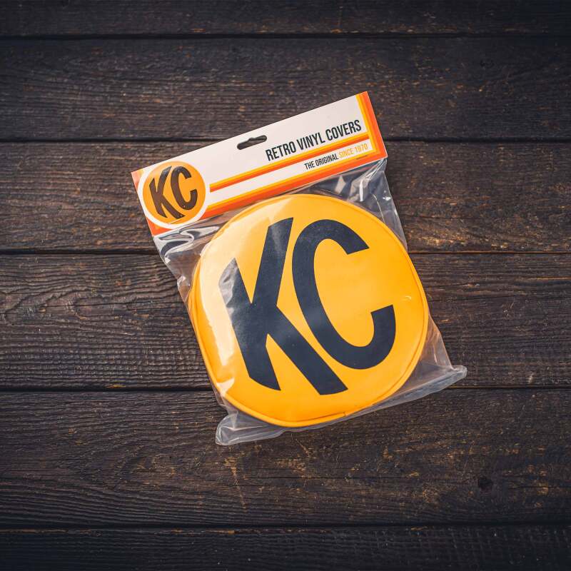 Pair of KC HiLiTES 8-inch round yellow vinyl light covers with black KC logo for vehicle lighting.