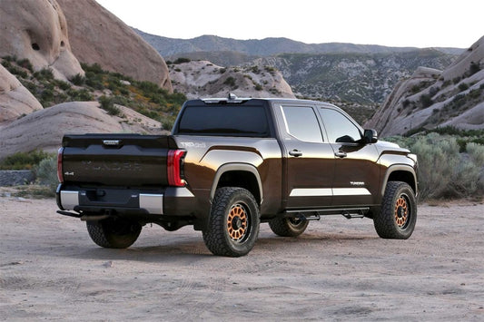 Fabtech rear coil spacer kit for lift kits, showing black spacers and mounting hardware on a vehicle suspension.