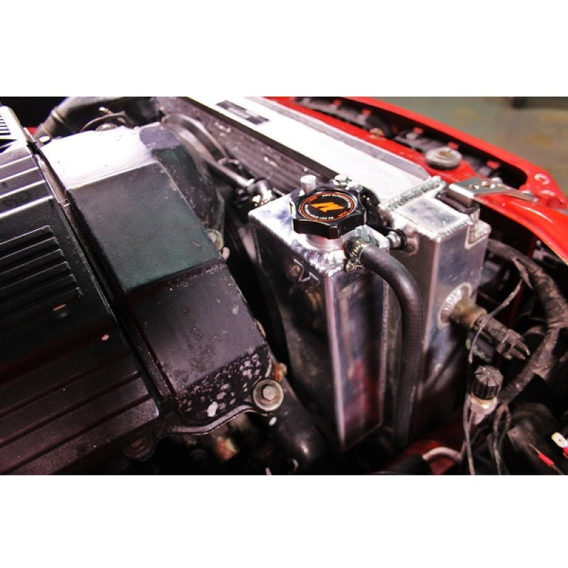 Mishimoto aluminum coolant expansion tank for BMW 3 Series 92-99, showing the sleek metallic reservoir with attached hoses.