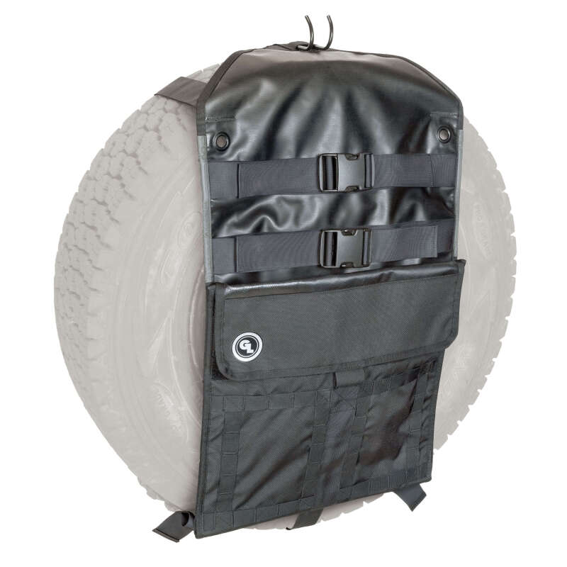 Giant Loop Overland Sling black spare tire carrier attached to motorcycle, durable nylon strap system for secure tire transport.
