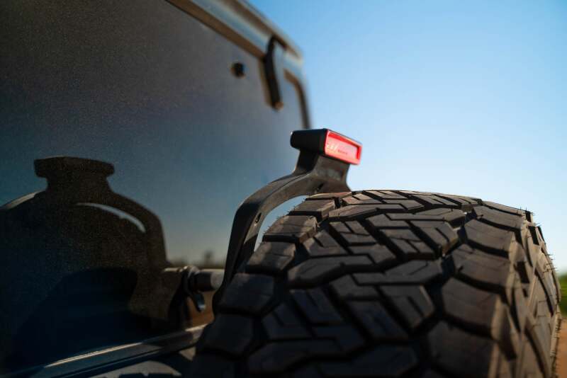 DV8 Offroad Jeep Wrangler JL MTO Series bumper spare tire swing gate tailgate accessory, showing the rugged design and mounting hardware