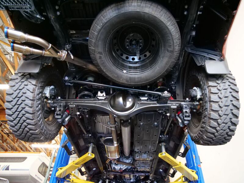 HKS Legamax Trail Master 2022 Tundra catback exhaust system installed on a pickup truck, showcasing its sleek stainless steel design.