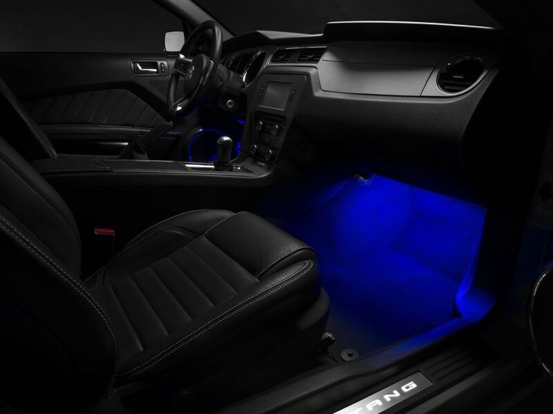 Blue LED footwell lighting kit for 2005-2014 Ford Mustang by Raxiom, installed in the car's interior footwell area.