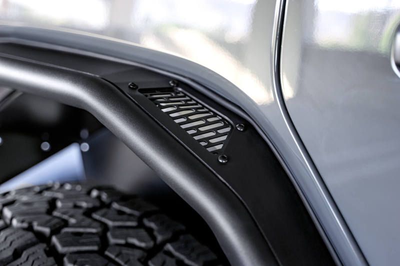 DV8 Offroad Jeep Wrangler JL Spec Series Tube Fenders, black metal with tubular design, installed on a Jeep Wrangler JL.