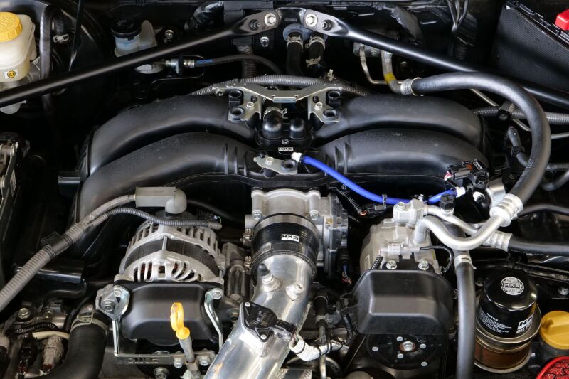 HKS pressure sensor kit for FA20/FA24 engines, gauge component with wires and sensor module in close-up view.