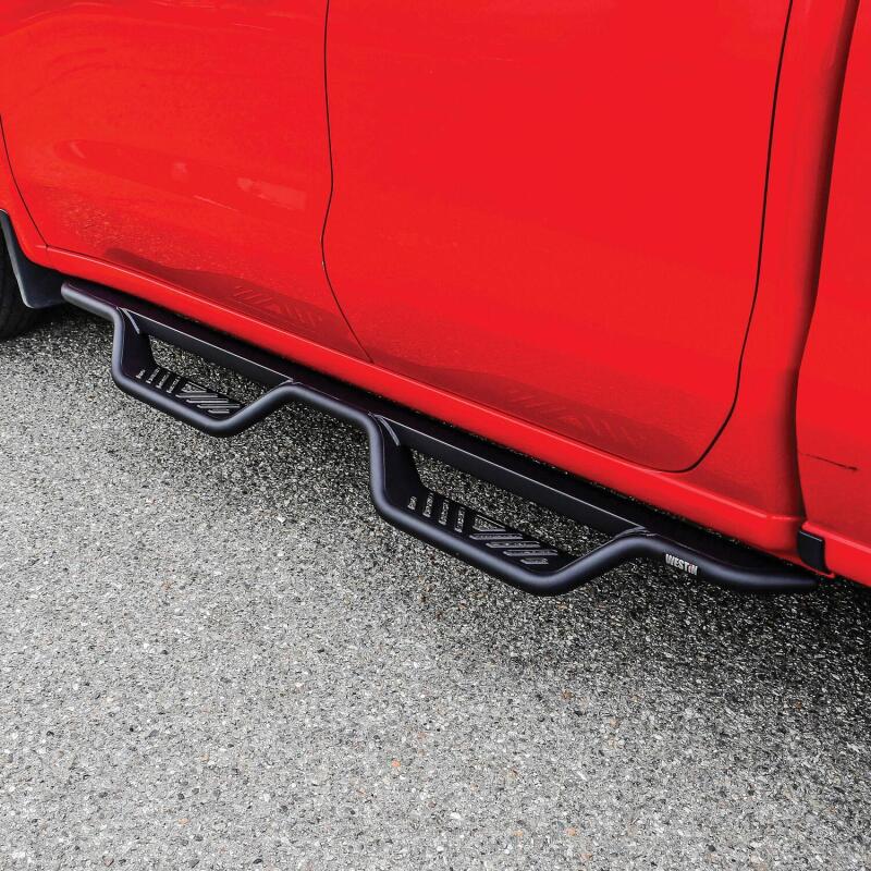 Westin Outlaw Drop Nerf Bars in Tex Black installed on Chevy Silverado and GMC Sierra double cab trucks, rugged side step bars