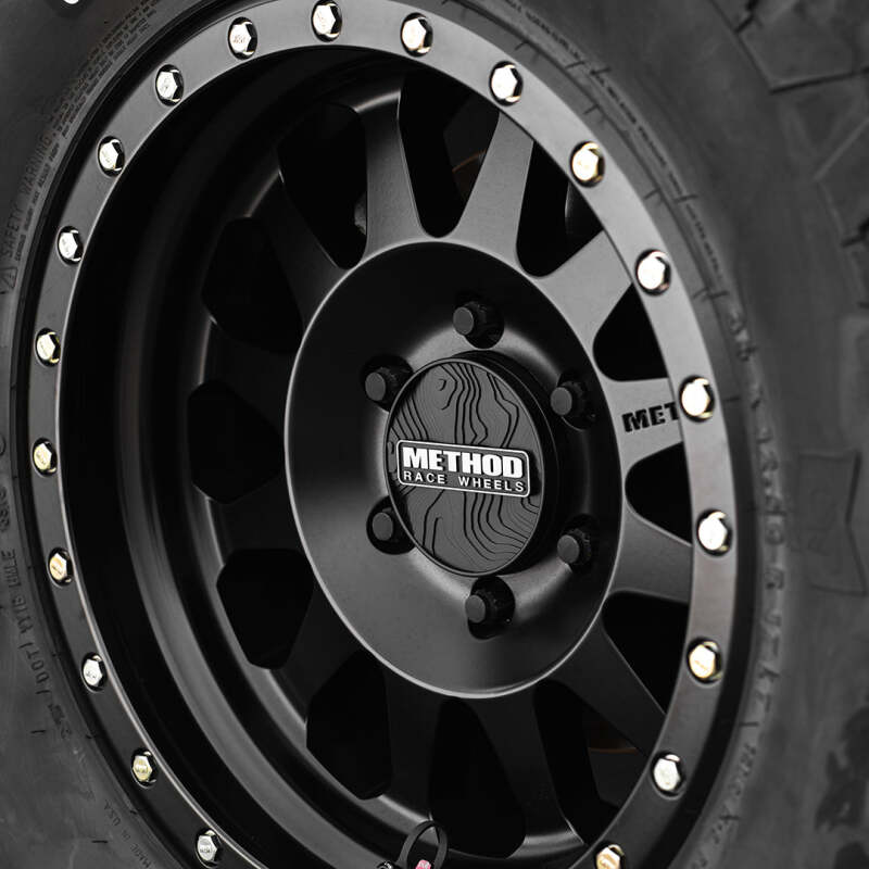 Black Method Wheels Cap TOPO 64mm snap-in wheel center cap shown on a vehicle wheel.