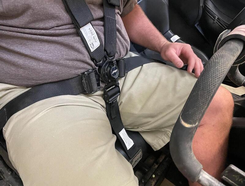 PRP Seats adjustable 5th point crotch belt for cam-lock harness, shown in black with secure buckle and strap details.
