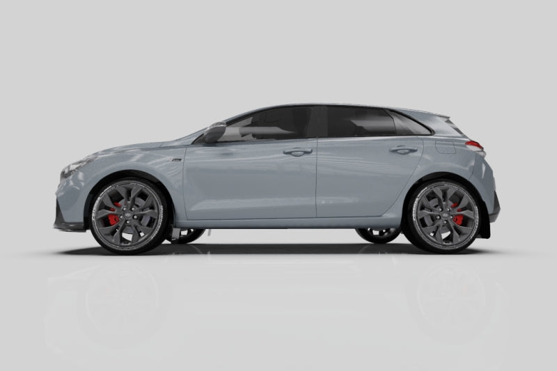 Rally Armor black mud flaps with blue logo installed on a 2019-2021 Hyundai Elantra GT N Line or i30, front view.