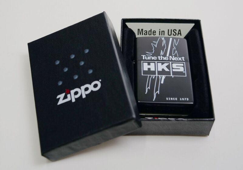 HKS Zippo lighter with TTN branding, metal case featuring detailed design and classic flip-top lid.
