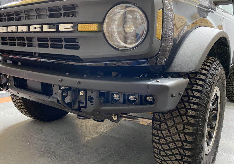 ORACLE Lighting Ford Bronco 21-22 triple LED fog light kit with white lights installed on steel bumper, front view.