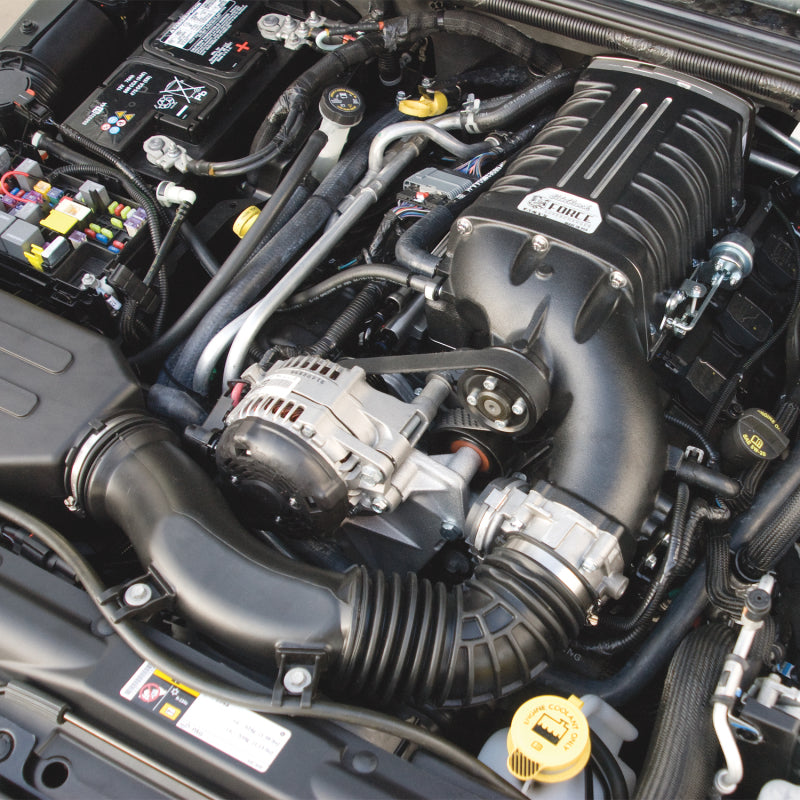 Edelbrock Supercharger Stage 1 Street Kit installed on a 2012-2014 Jeep Wrangler 3.6L V6 engine, with visible supercharger components.