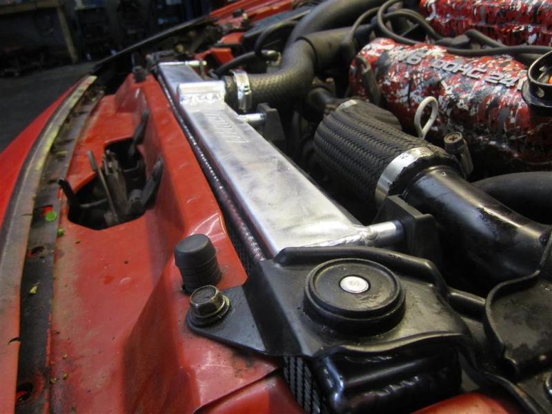 Mishimoto aluminum radiator for 1991-1999 Mitsubishi 3000GT Turbo manual transmission, with core and side tanks visible.