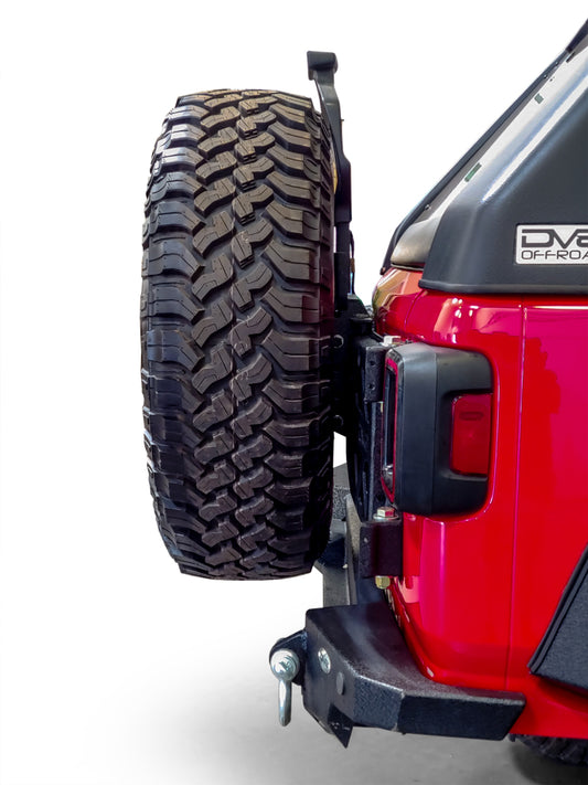 DV8 Offroad Jeep Wrangler tire carrier chase rack mounted on 2018+ model, featuring durable steel construction and off-road design.