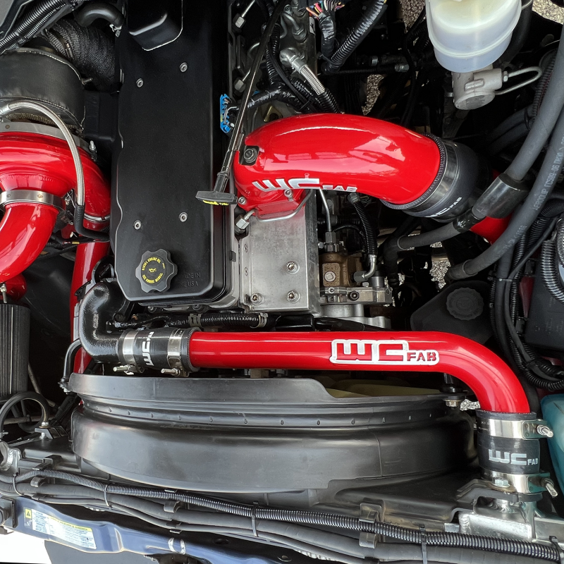 Wehrli 03-09 Cummins upper coolant pipe in Illusion Blueberry, radiator hose with smooth, curved design for engine cooling system.