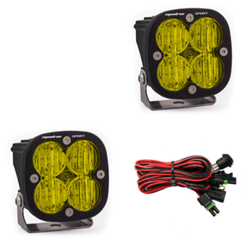 Pair of Baja Designs Squadron Sport LED light pods with amber lenses, designed for wide cornering, mounted on a vehicle.