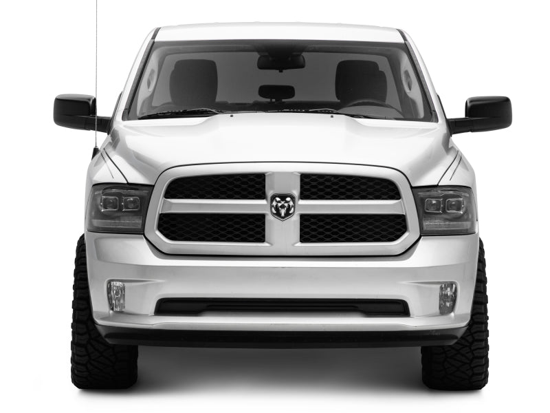 Raxiom LED projector headlights for 2009-2018 RAM 1500 with black housing and clear lens, featuring switchback turn signals.