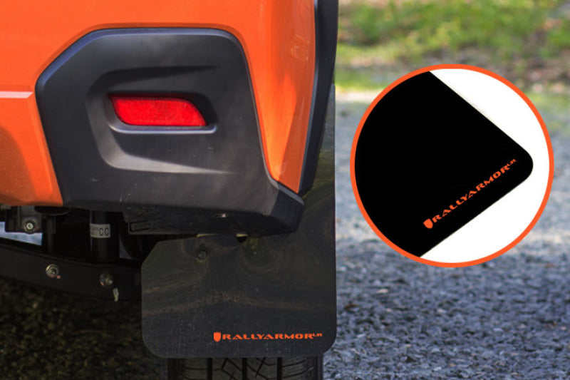 Rally Armor black mud flaps with orange logo on a 2013-2017 Subaru Crosstrek XV, providing protection and style.