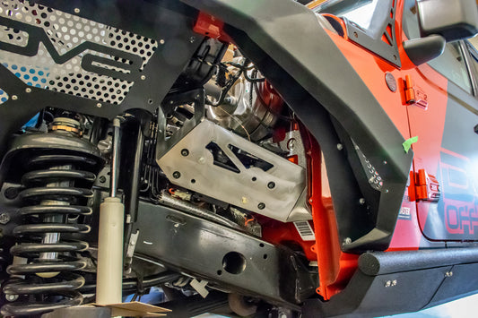 DV8 Offroad Jeep JL/JT engine bay compressor mount for air suspension, shown mounted in vehicle engine compartment.