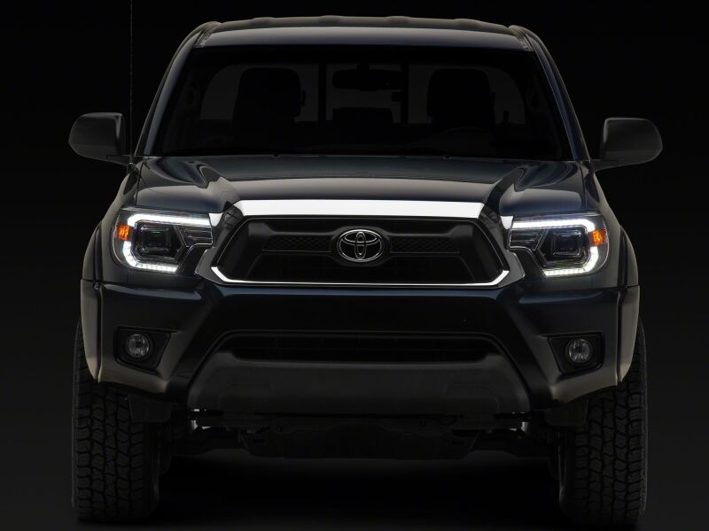 Raxiom 12-15 Toyota Tacoma Axial Series projector headlights with chrome housing and clear lens, showcasing sleek headlight design.