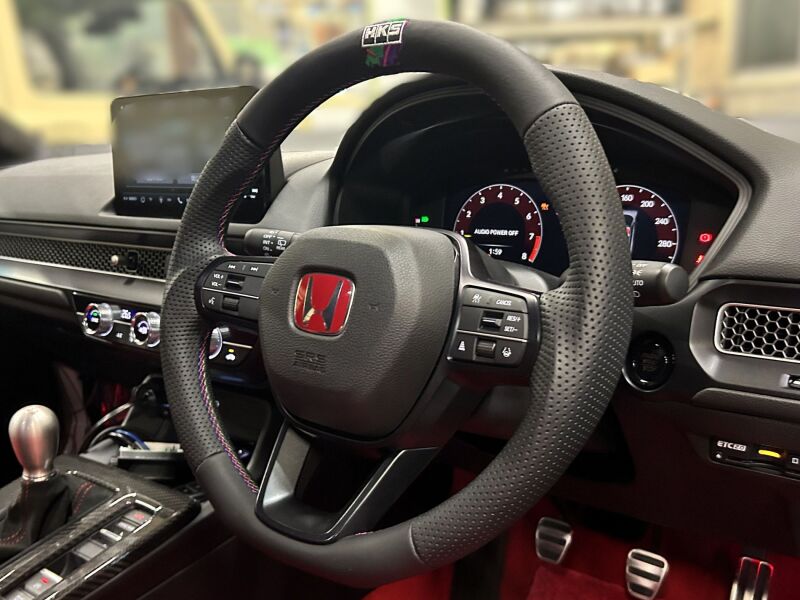 HKS Honda Civic FL5 replacement steering wheel with sporty grip and sleek design, shown from an angle with visible branding.