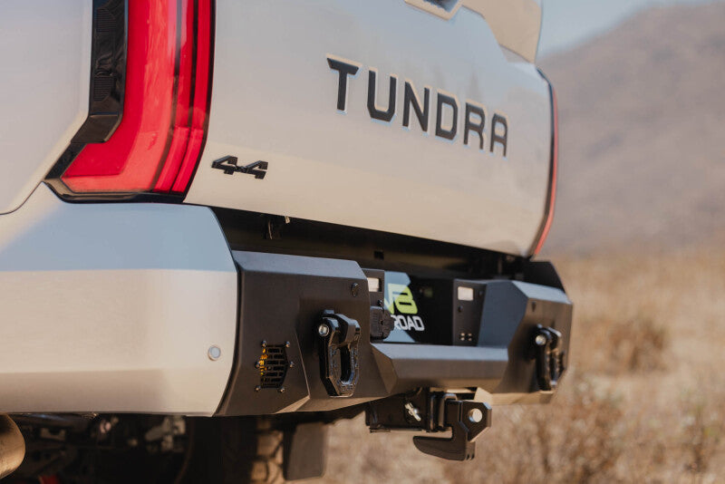 Steel rear bumper for Toyota Tundra from DV8 Offroad's Spec Series, shown in black with mounting brackets.